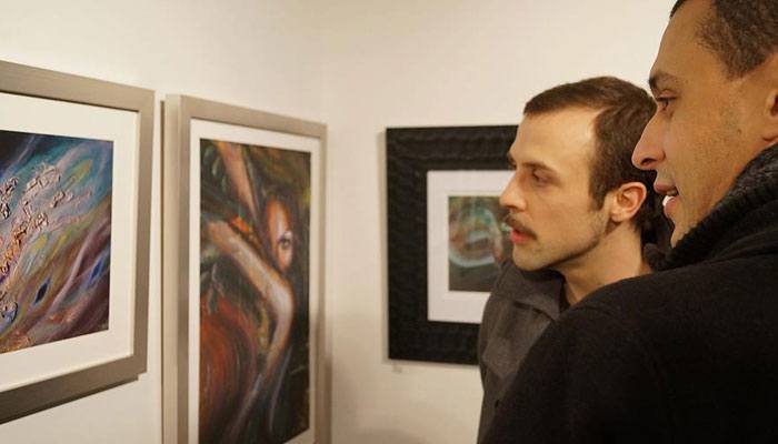 Art exhibition attendees viewing artwork by Tanja Groos